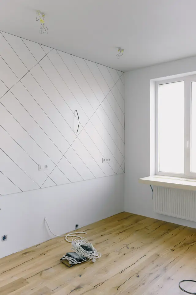 Pièce en travaux, parquet posé et câbles électriques en attente au sol